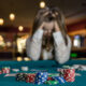 Upset woman in casino sitting behind poker table
